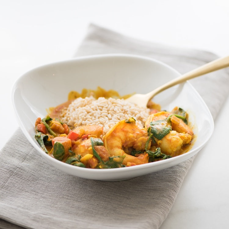 White bowl with shrimp curry and rice on a white background