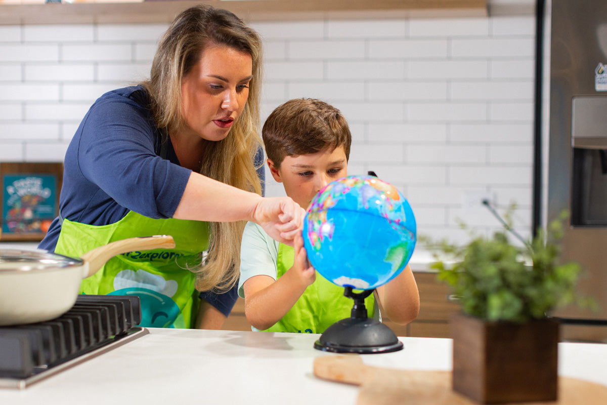woman child learning with globe kitchen