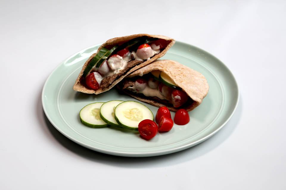 whole wheat pita stuffed with tomatoes cucumber sauce on plate