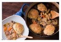 beef stew with dumplings in pot and plate