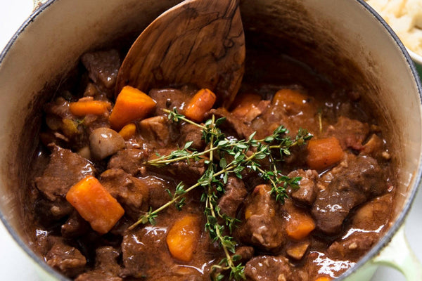 beef stew with carrots and thyme in pot mashed potatoes