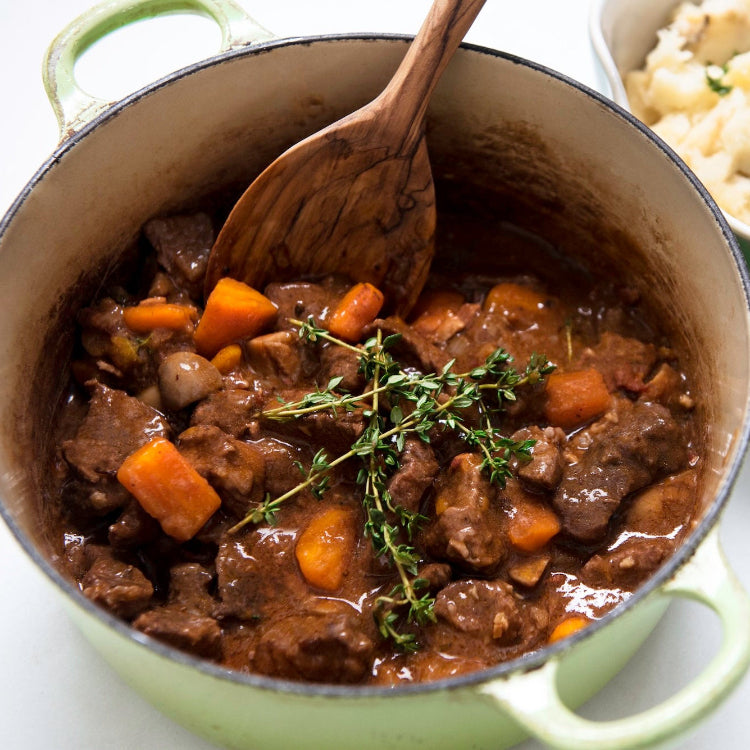 beef stew with carrots and thyme in pot mashed potatoes